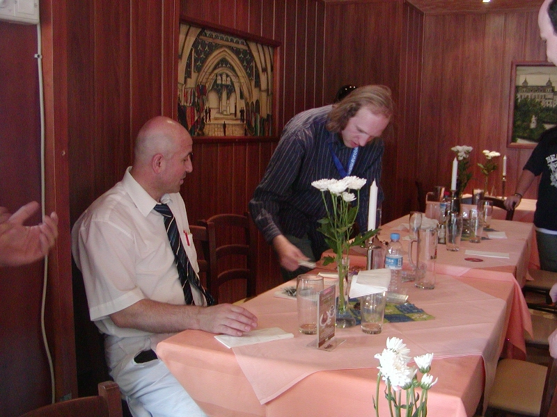 A very amused restaurantowner receives his money.