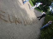 Luise writing the url in the sand.